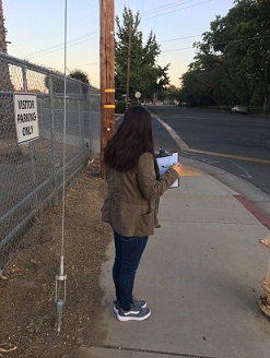 Student on sidewalk with clipboard